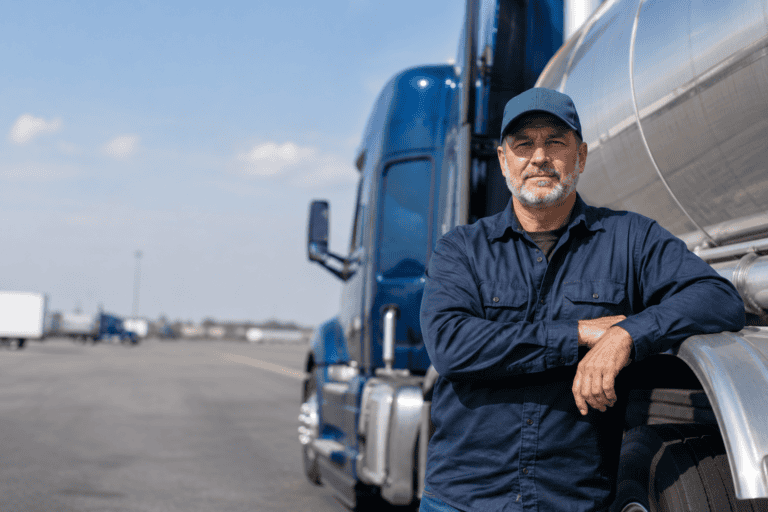Truck driver with hazmat placarded trailer representing the difference between a hazmat endorsement and 172.704 training